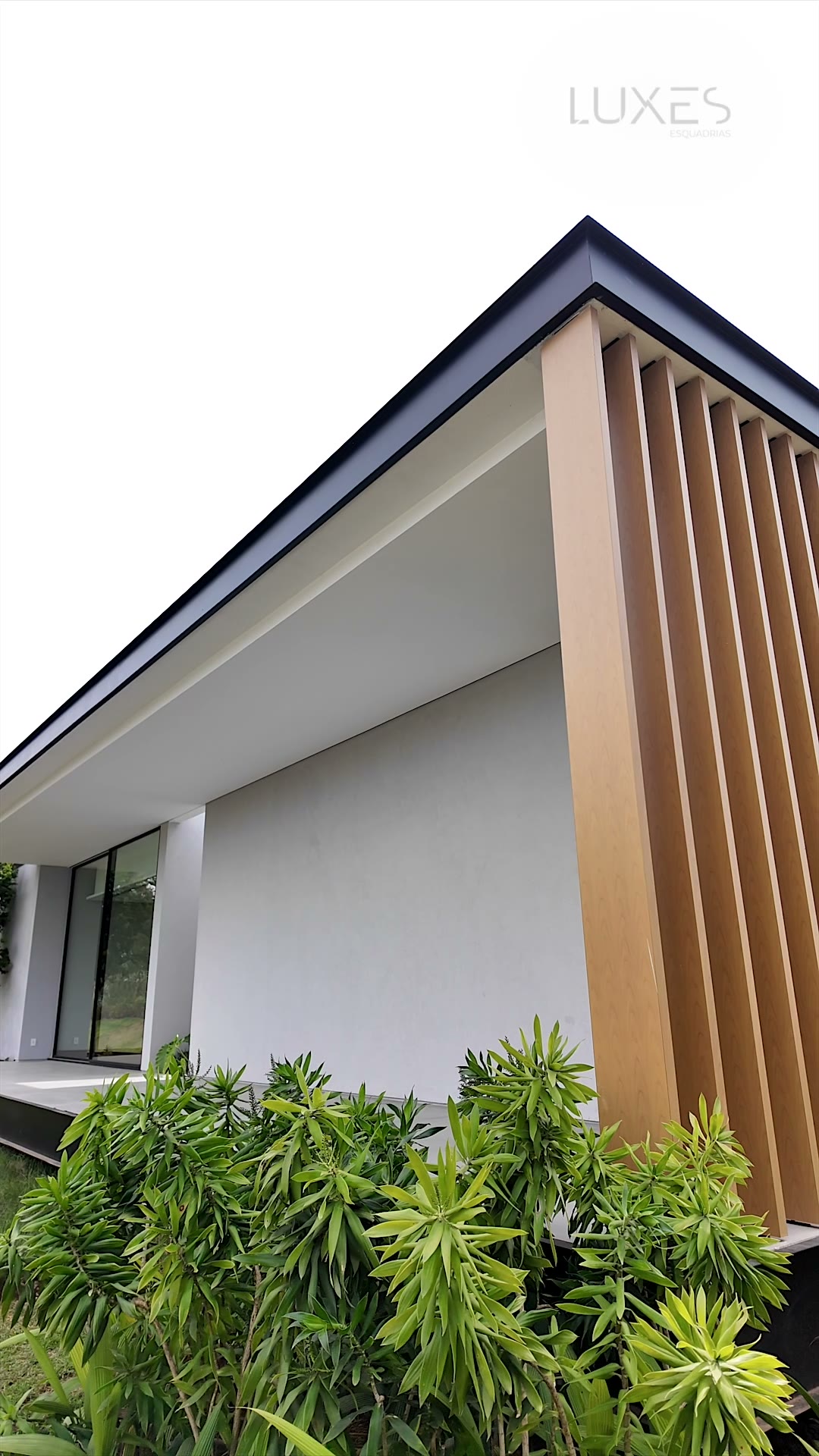 Fachada minimalista com ripado de alum&iacute;nio em efeito madeira, projeto de Jo&atilde;o Armentano na Fazenda Boa Vista &mdash; Luxes Esquadrias